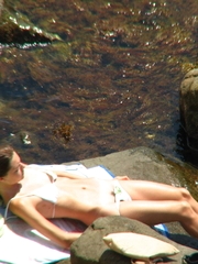 Slender lass is a little bit shy while in a nudist beach