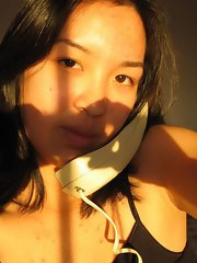 Cute Asian plays with camera in her room by taking selfpics